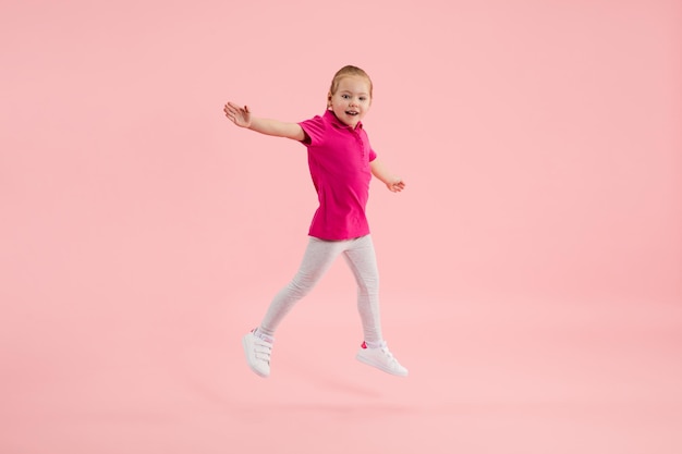 Childhood and dream about big and famous future Pretty little girl isolated on coral pink background