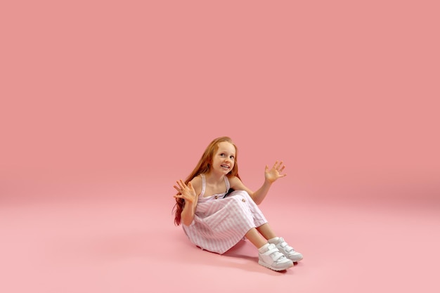 Childhood and dream about big and famous future Pretty longhair girl isolated on coral pink background