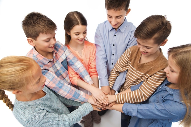 Photo childhood, fashion, friendship and people concept - happy children with hands on top