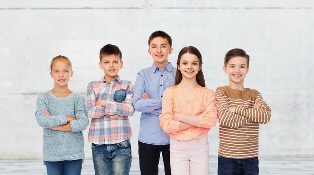 childhood, friendship and people concept - happy smiling children over urban street background