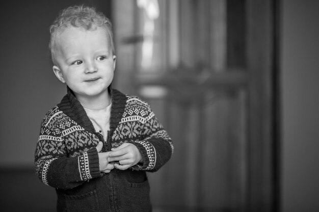 Childhood fun and people concept happy little boy behind door at home