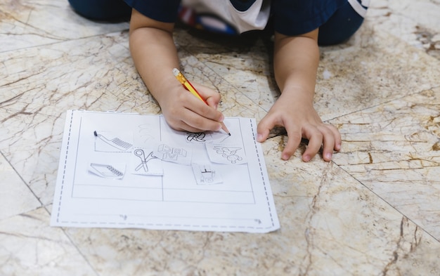 Childhood learning to use a pencil to draw and write on paper.