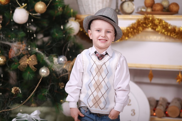 Childhood memories. little boy in hat celebrate christmas at home. Boy child play near christmas tree. Merry and bright christmas. Childhood activity and game. Family holiday.