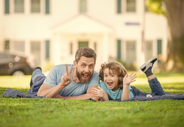 Childhood and parenthood parent relax with little child boy on grass dad with kid