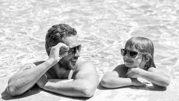 Childhood and parenting friendship father and son wear glasses in swimming pool water