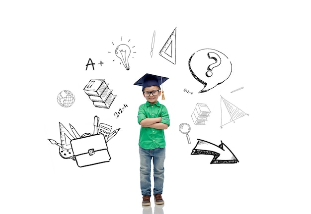 childhood, school, education, learning and people concept - happy boy in bachelor hat or mortarboard with doodles