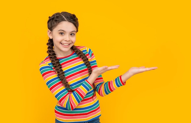 Childhood studio shot of teen girl presenting product concept of childhood teen braided girl