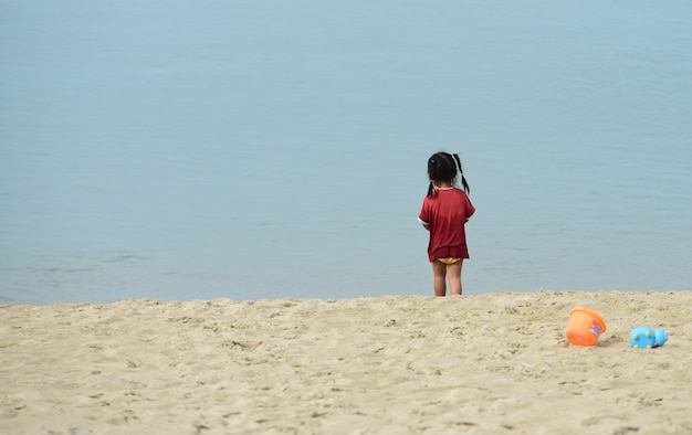 Children are having fun at the beach on a beautiful day the sky is clear