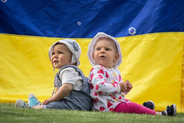 Children on the background of the flag of Ukraine Little boy and girl babies close up