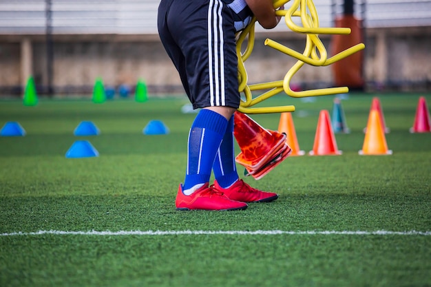 Photo children ball is collecting tactics on grass field with  barrier for training skill in soccer academy