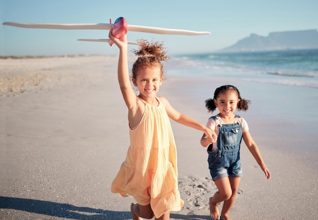 Children beach vacation and travel with happy girl sisters or siblings flying airplane toy running by seaside for fun activity with energy Portrait of kids on tropical family holiday in costa rica