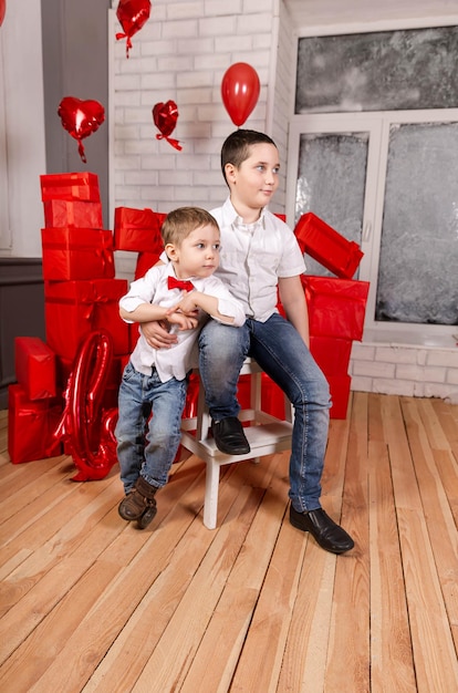 Children boys open birthday present gift. Two beautiful kids. Congratulate mother with mothers day or birthday. Adorable children making surprise to mum at home. Happy cute kids give present to mom