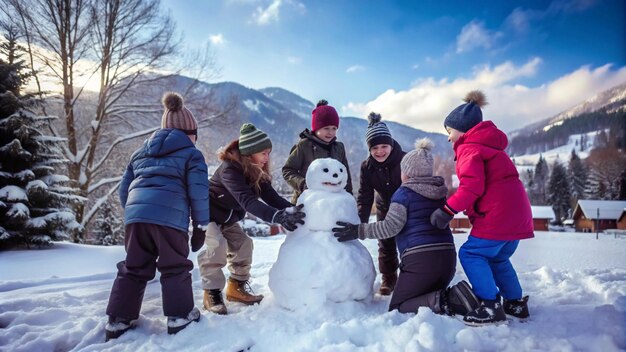 Photo children building a snowman in a snowy landscape with mountains in the background