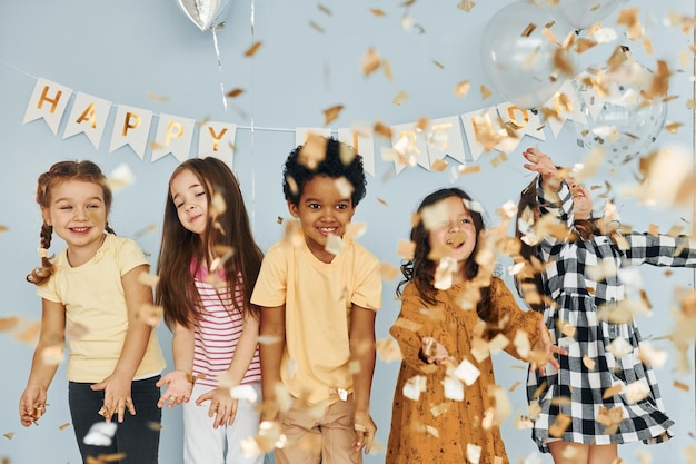 Children on celebrating birthday party indoors have fun together