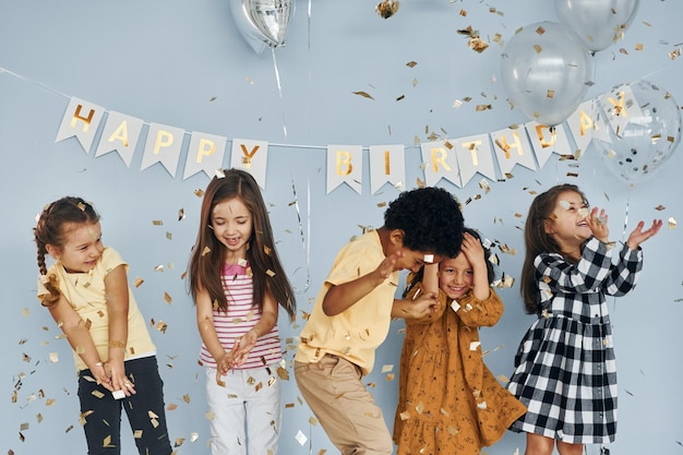 Children on celebrating birthday party indoors have fun together