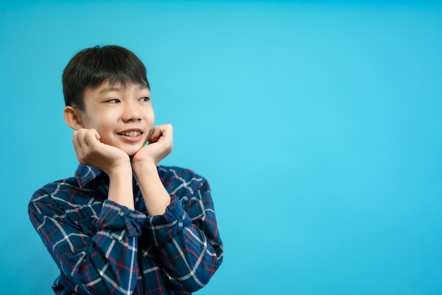 Children close up photo of cute and cheerful people, looking and smile on blue pastel background