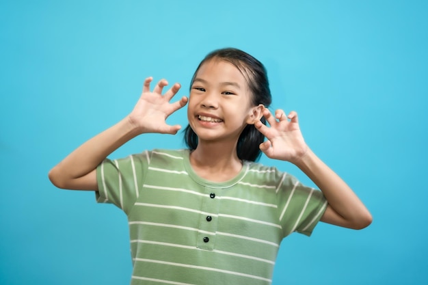 Children close up photo of cute and cheerful people, looking and smile on blue pastel background