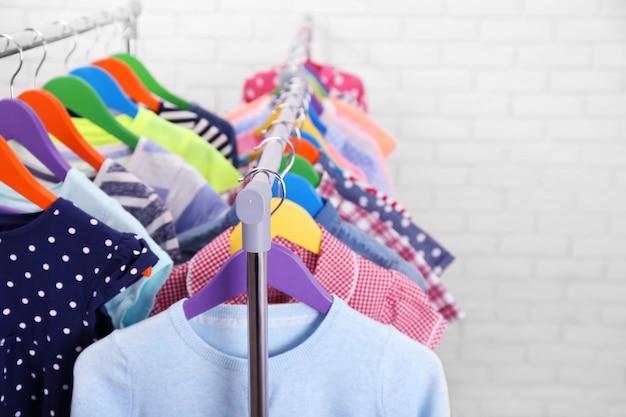 Children clothes on hangers in a room