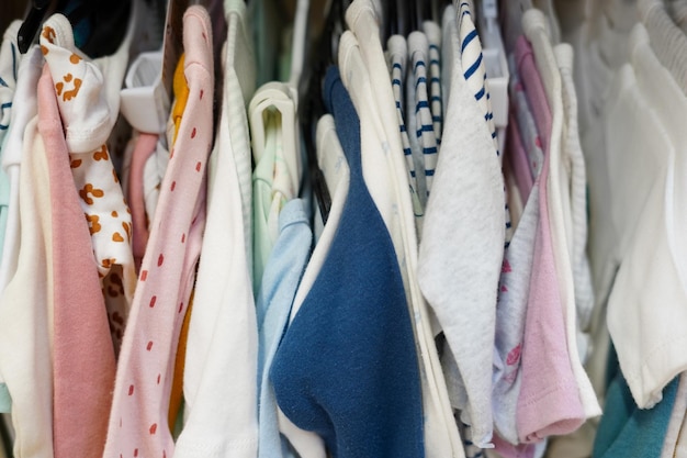 Children clothes hanging on hangers in the shop