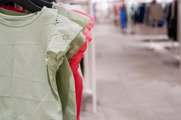 Children clothes hanging on hangers in the shop