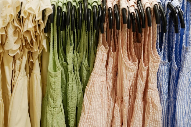 Children clothes summer dresses hanging on hangers in the shop