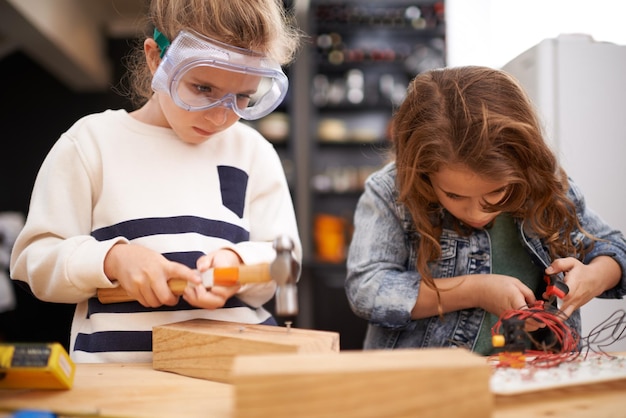 Children construction and diy in workshop with tools play and game in kitchen of home Girls hammer and safety glasses for wood project or building carpentry and woodworking or manufacture