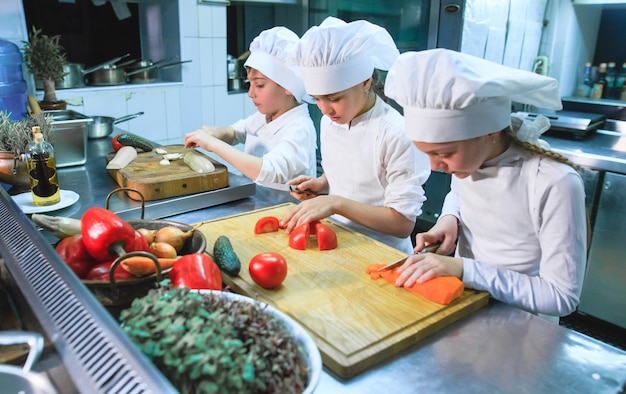 Children cooking lunch in a restaurant kitchen.