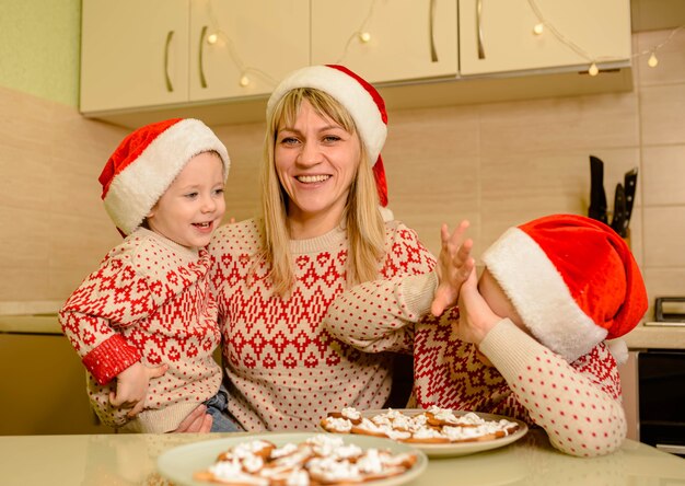 Children decorate Christmas cookies with sugar glaze. Cute caucasian child boys decorating gingerbread cookies with fun.