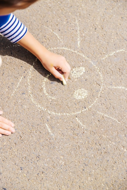 Children draw on the pavement with chalk Selective focus