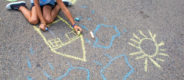 Children draw the Ukrainian flag house on the pavement Selective focus