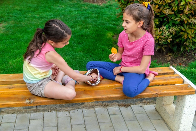 Children eat chips in a friend's park Selective focus