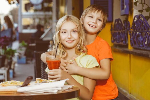 Children eat pizza and drink juice outdoor