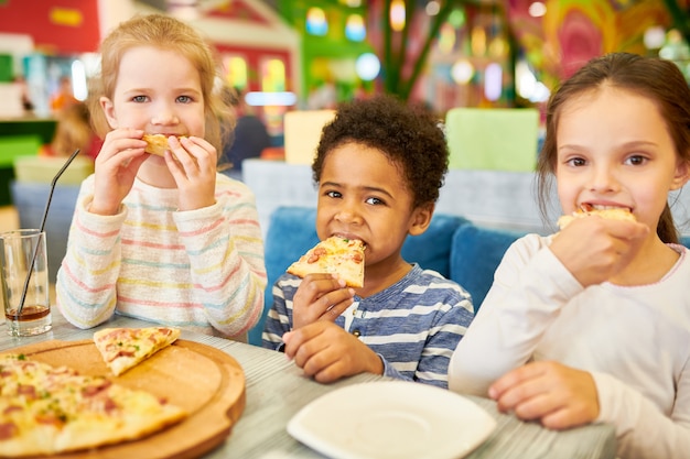 Children Eating Pizza in Cafe