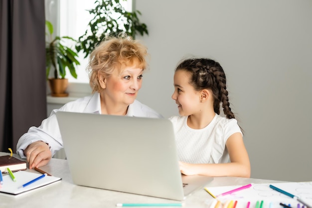 Children and education, teacher or grandmother teaching with notebook by internet to girl.