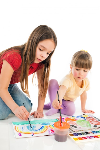 Children enthusiastically paint with watercolors