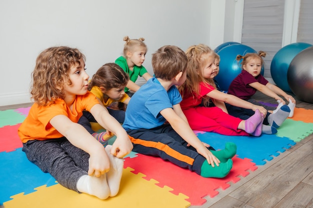 Children exercising while physical education lesson at preschool