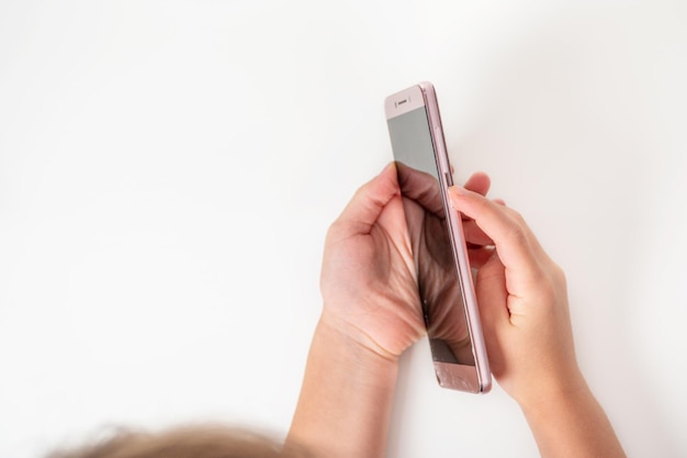 children fingers press the power button on the broken phone