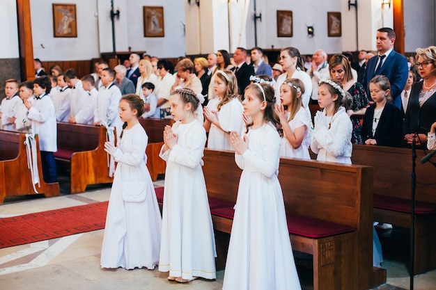 Children during the first communion in the church during prayer