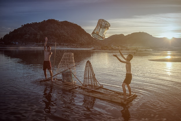 Children Fisherman boy with catching fish on lake river Thailand