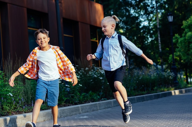 Children go to school with backpacks on sunny day Begining of academic year