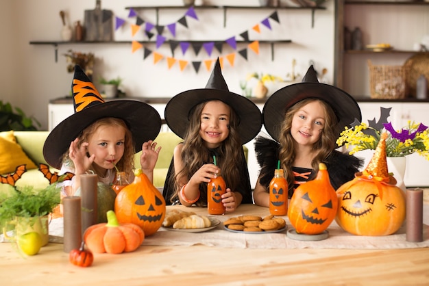 Children in halloween costumes with pumpkin fooled on holiday