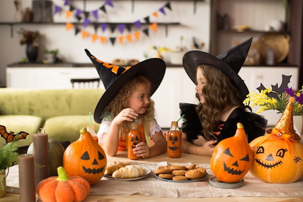 Children in halloween costumes with pumpkin fooled on holiday