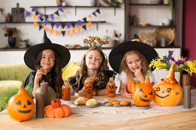 Children in halloween costumes with pumpkin fooled on holiday