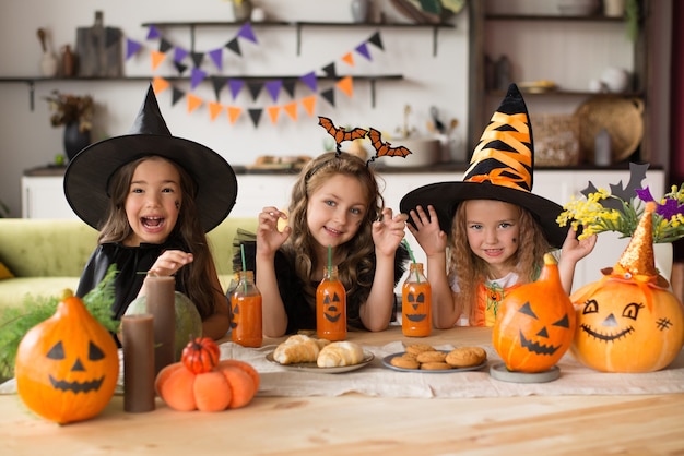 Children in halloween costumes with pumpkin fooled on holiday