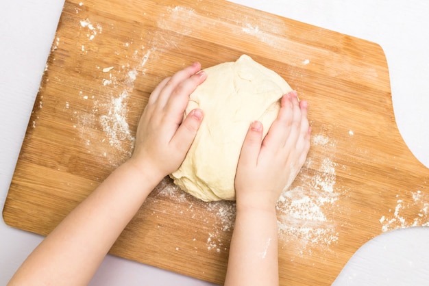 Children hands make a dough