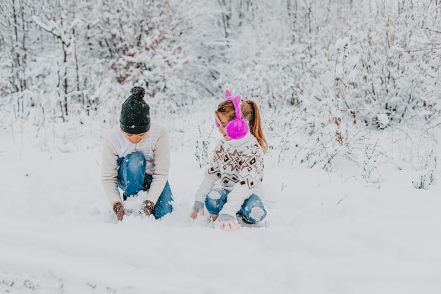 Children have fun playing in the snow. boy and girl running around in winter park. winter holidays