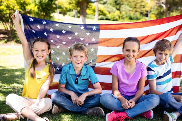 Children holding american flag in park