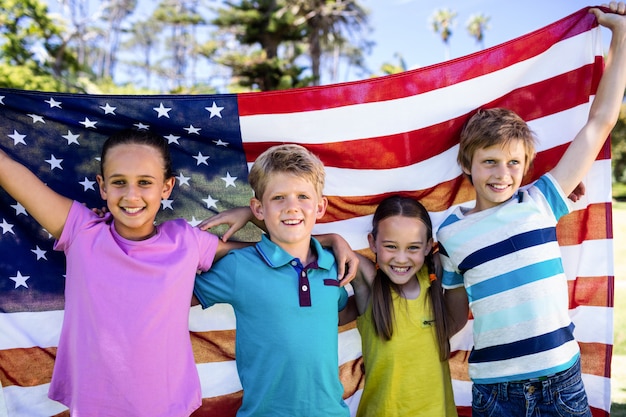 Children holding american flag in park