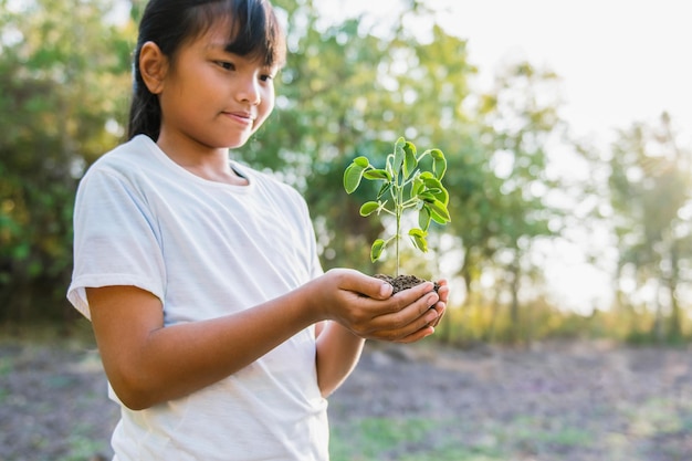 Children holding small tree for planting concept earth day