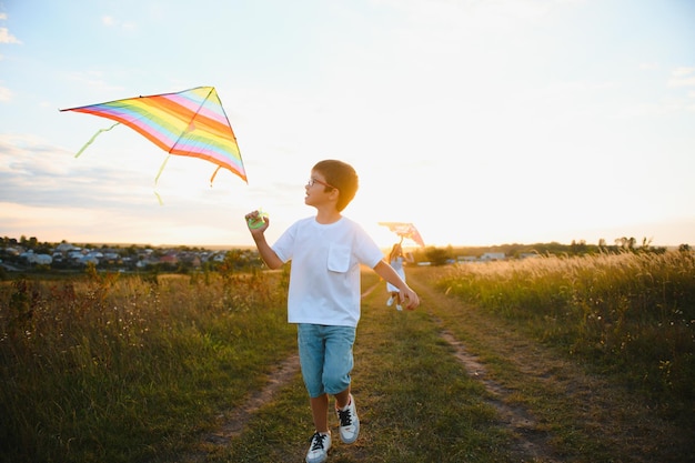 Children launch a kite in the field at sunset